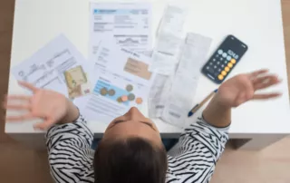 Woman stressed over bills, coins, receipts, and calculator